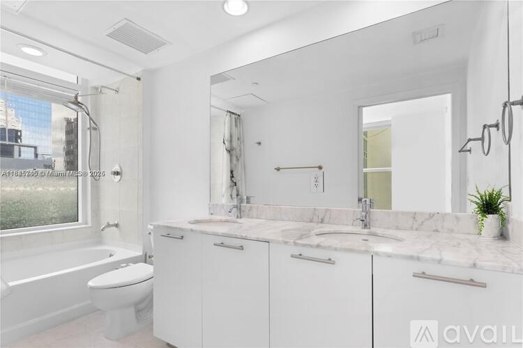 A white bathroom with a tub, sink, and mirror.