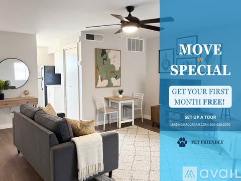 A living room with a grey sofa, a white ceiling fan, and a painting on the wall.