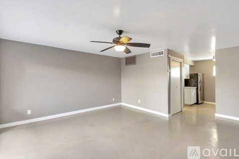 A room with a ceiling fan and a door leading to another room.