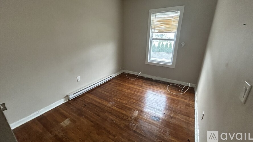 A room with wooden flooring and a window.
