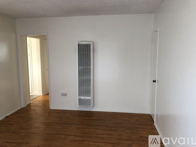 A room with a white wall and a white door with a window.