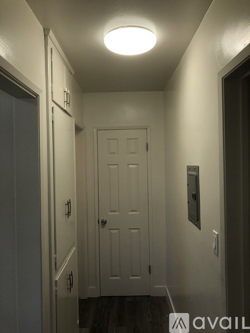 A hallway with a door and a light on the ceiling.