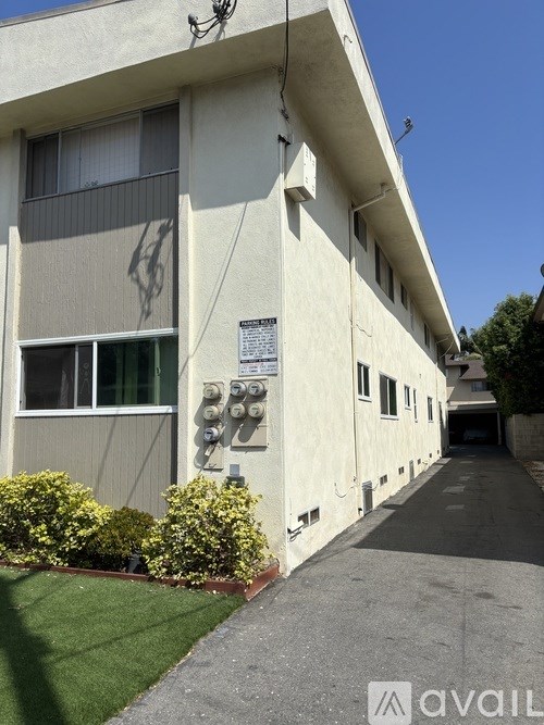 A kitchen with a stainless steel refrigerator and white cabinets.