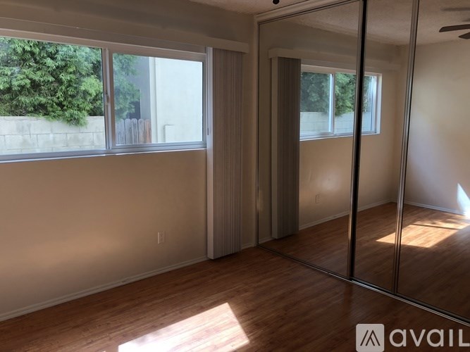 A room with a sliding glass door and a wooden floor.
