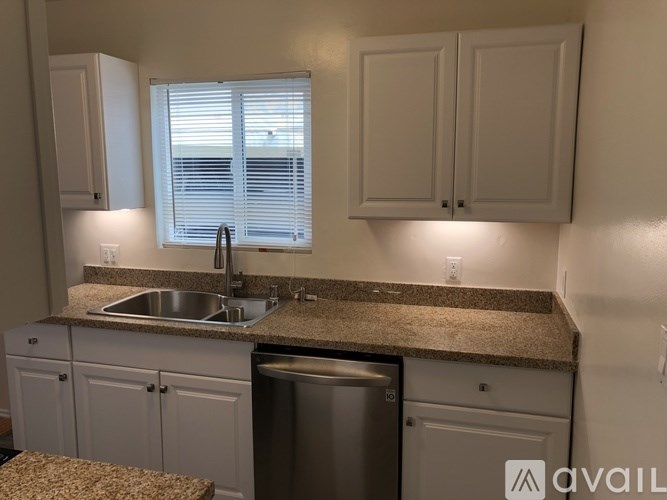 A kitchen with granite countertops and white cabinets.