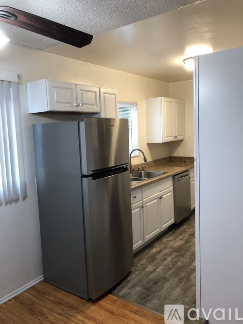 A kitchen with a stainless steel refrigerator and white cabinets.