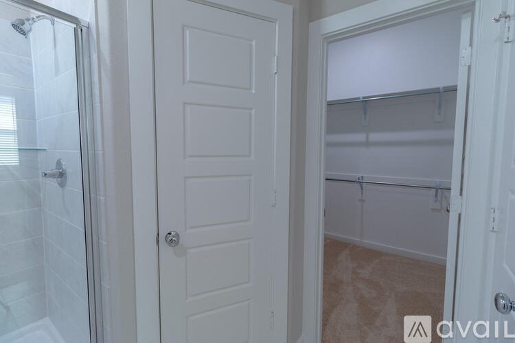 A white door with a glass shower stall to its left.