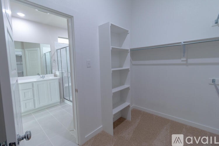 A bathroom with a white door and a mirror on the wall.