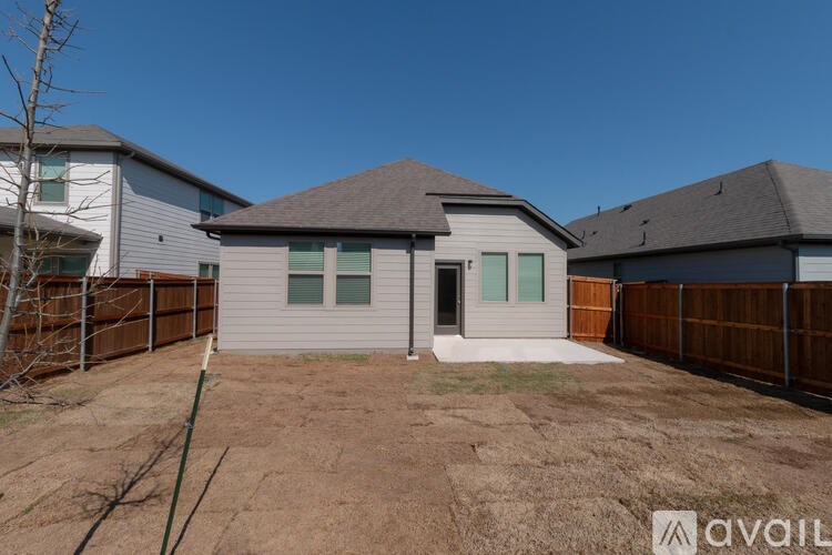 A house with a brown fence and a brown roof is for sale.