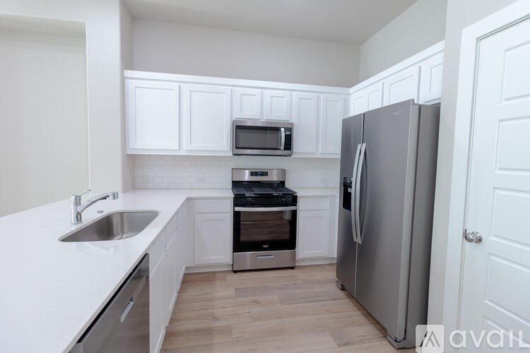 A kitchen with white cabinets and a stainless steel refrigerator.