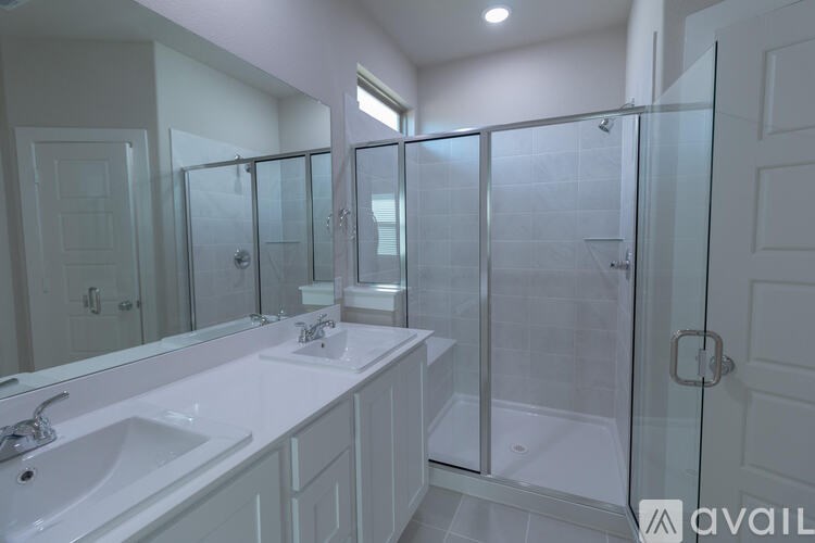 A bathroom with a white sink and a walk-in shower.