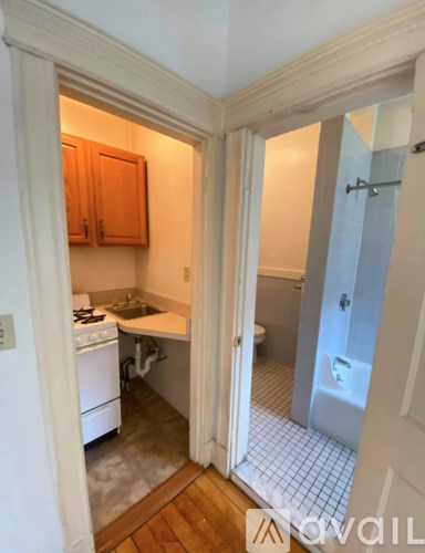 A small kitchen with a white stove and wooden cabinets.