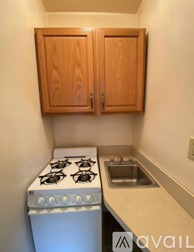 A kitchen with a stove, sink and cabinets.