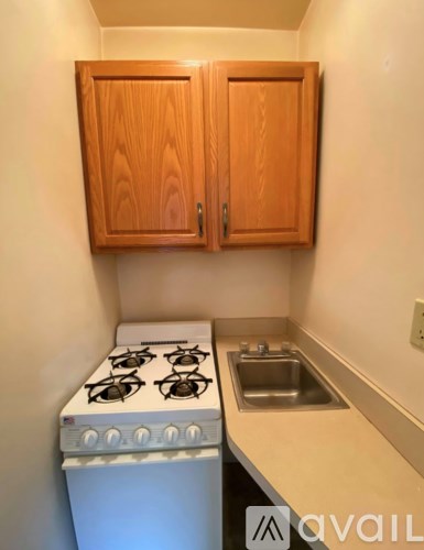 A kitchen with a stove, sink and cabinets.