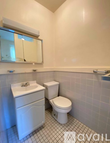 A white toilet and sink in a bathroom.