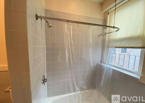 A shower area with a glass door and a window.