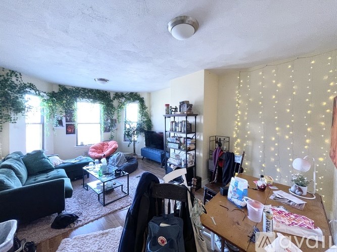 A living room with a couch, a chair, a coffee table, and a TV.