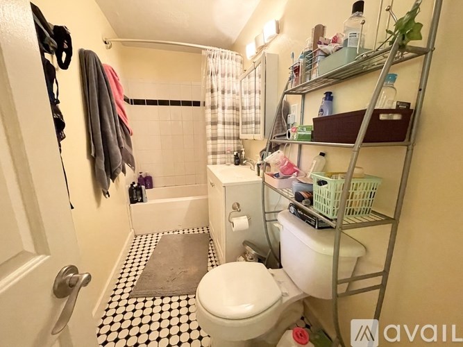 A bathroom with a toilet, sink, and a shower.