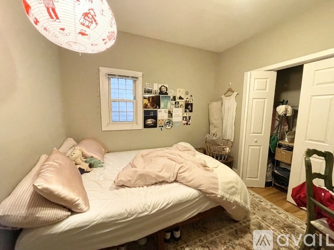 A bedroom with a bed, a window, and a closet.