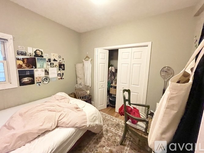 A bedroom with a bed, chair, and pictures on the wall.