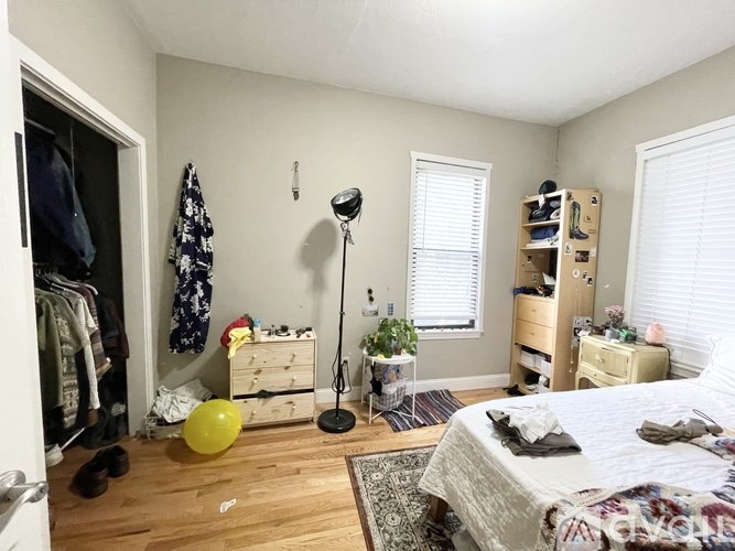 A bedroom with a bed, dresser, and closet.