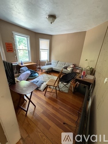 A living room with a couch, chair, and television.
