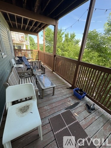 A white chair sits on a wooden deck with a table and a blue box.