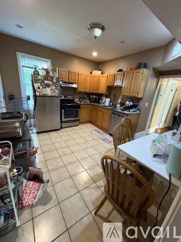 A kitchen with wooden cabinets and a white table.