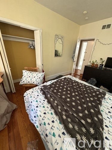 A bed with a brown and white comforter is in a room with a brown headboard.