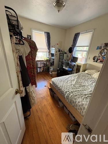 A bedroom with a bed, a wardrobe, and a window.