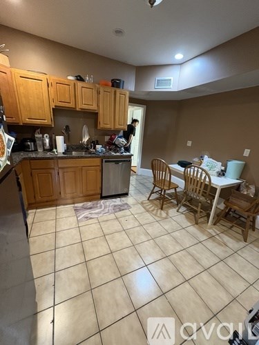 A kitchen with wooden cabinets and a person standing in the doorway.