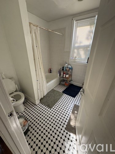 A white bathroom with a black and white checkered floor.