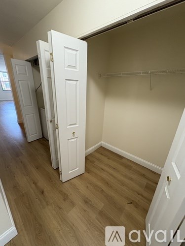 A room with white doors and wooden floors.