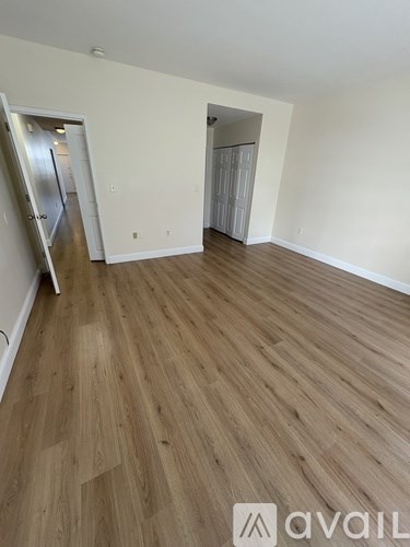 A room with wooden flooring and two doors.