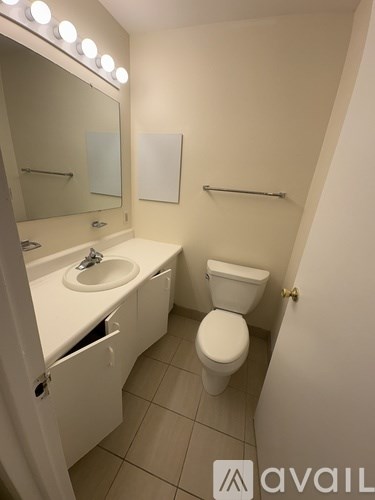 A bathroom with a toilet, sink, and mirror.