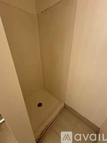 A small shower in a bathroom with a tiled floor.