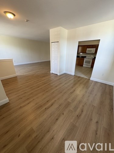 A room with wooden flooring and a white door.