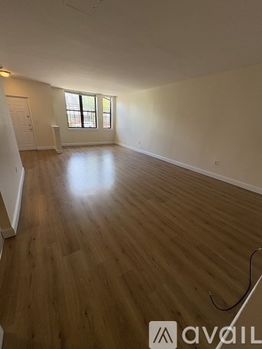 A room with wooden flooring and a window.