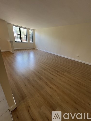 A room with wooden flooring and a window.