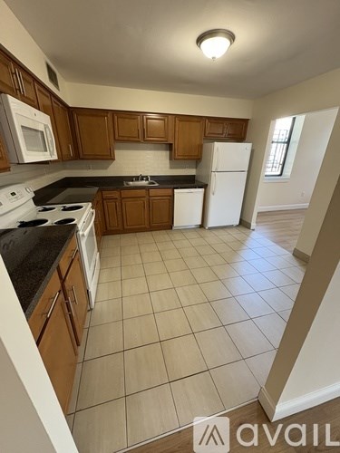 A kitchen with wooden cabinets and white appliances.