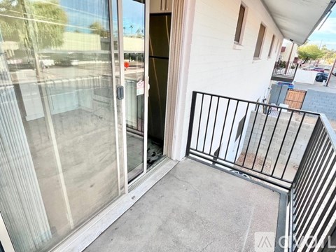 A balcony with a black railing and a glass door.
