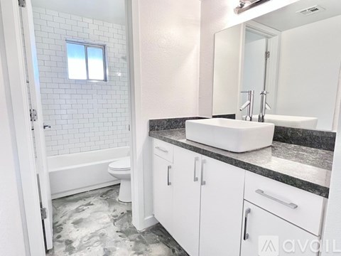 A bathroom with a white sink and a window.