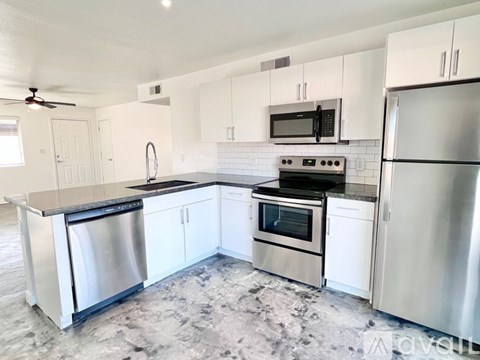 A kitchen with white cabinets and stainless steel appliances.