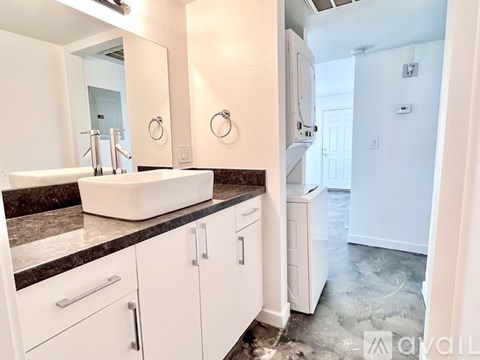 A bathroom with a sink, mirror, and cabinets.