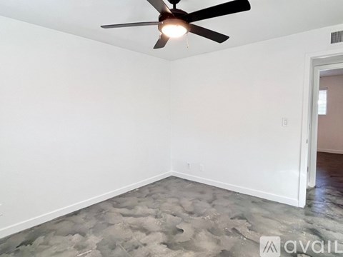 A room with a ceiling fan and a door.