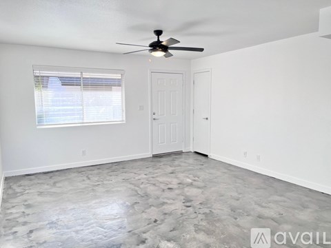 A room with a ceiling fan and a marble floor.
