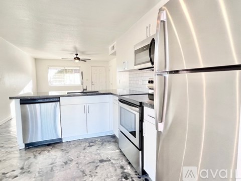 A kitchen with a refrigerator, microwave, and oven.