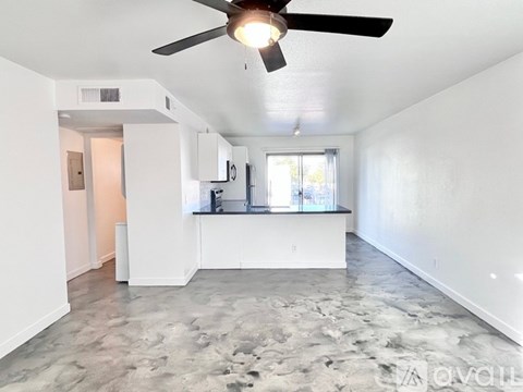 A room with a ceiling fan and a marble floor.