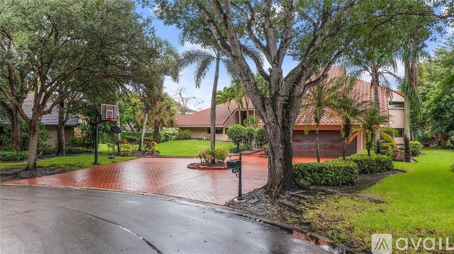A house with a red roof and a basketball hoop in the yard.