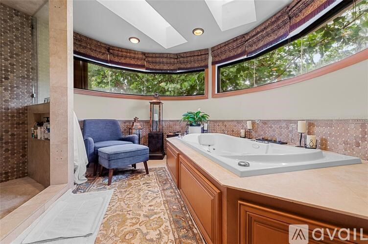 A bathroom with a blue chair and a large tub.